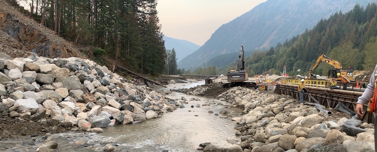 Environmental crews rebuilding a watercourse crossing on a pipeline right-of-way in a mountain valley